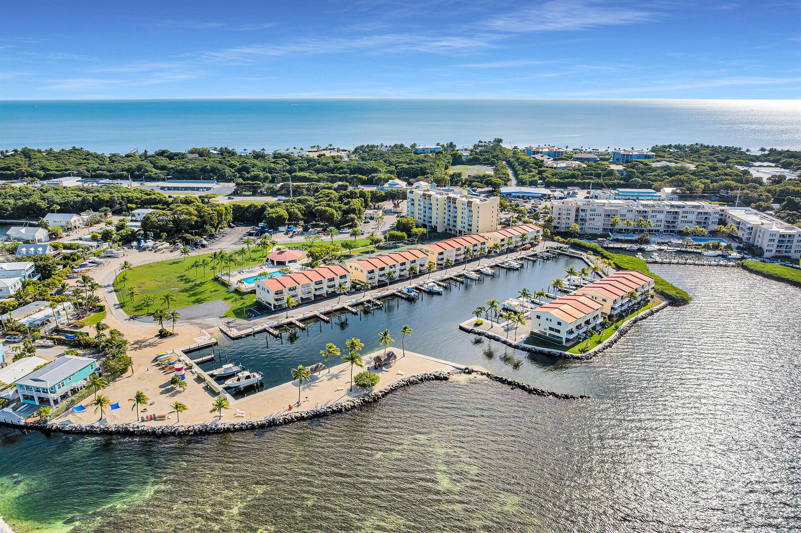 An aerial view shows a coastal resort with multi-story buildings, boat slips, and a marina — 88540 Overseas Highway # 304, Tavernier FL 33070, TAVERNIER, FL