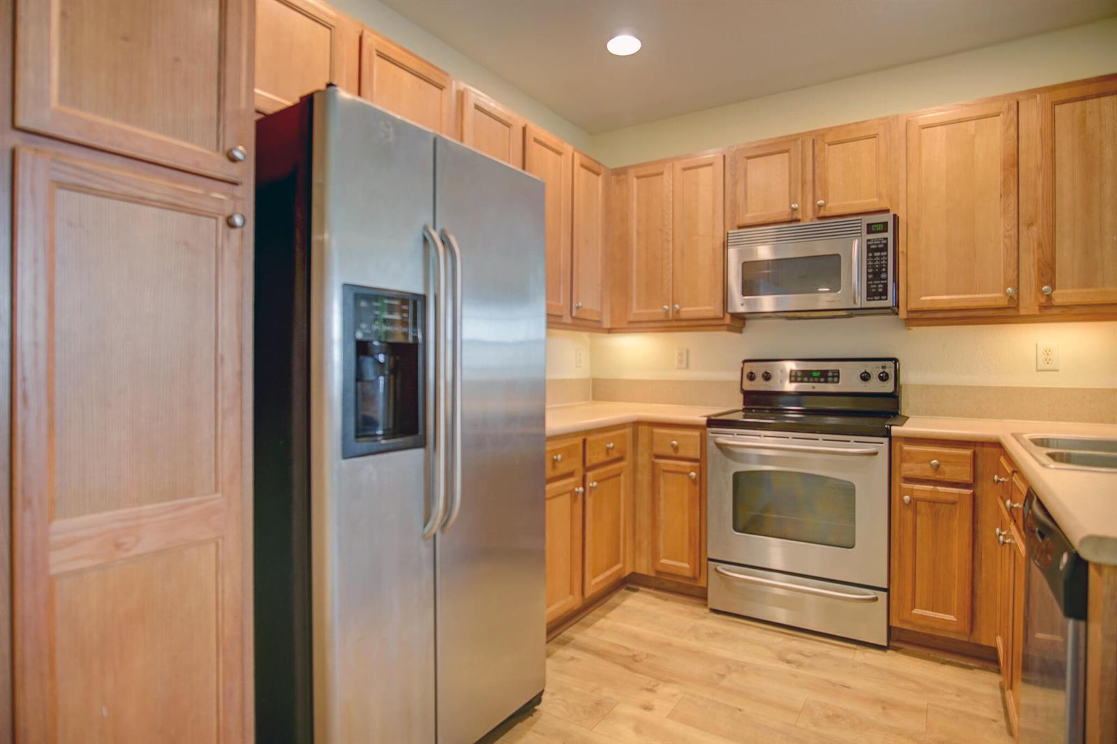 A kitchen with light wood cabinets, stainless steel appliances, and light-colored countertops — 1020 E Longport Circle # F2, Delray Beach FL 33444, DELRAY BEACH, FL