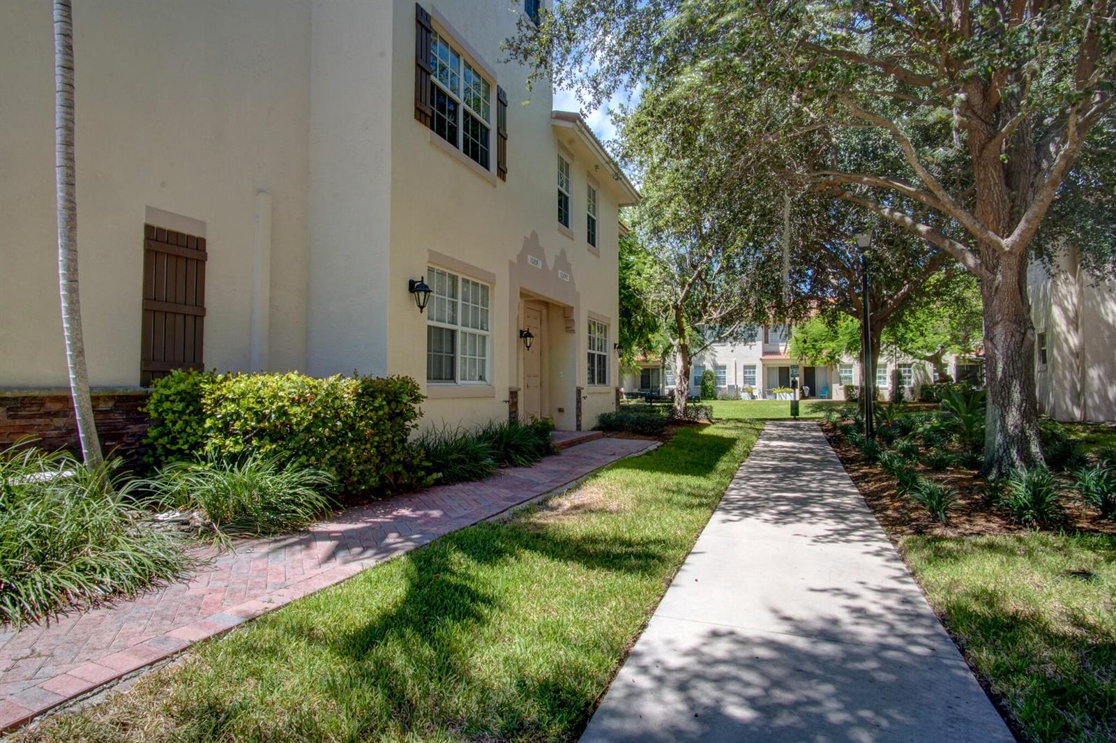 A beige multi-story building with a brick walkway and a concrete sidewalk — 1020 E Longport Circle # F2, Delray Beach FL 33444, DELRAY BEACH, FL