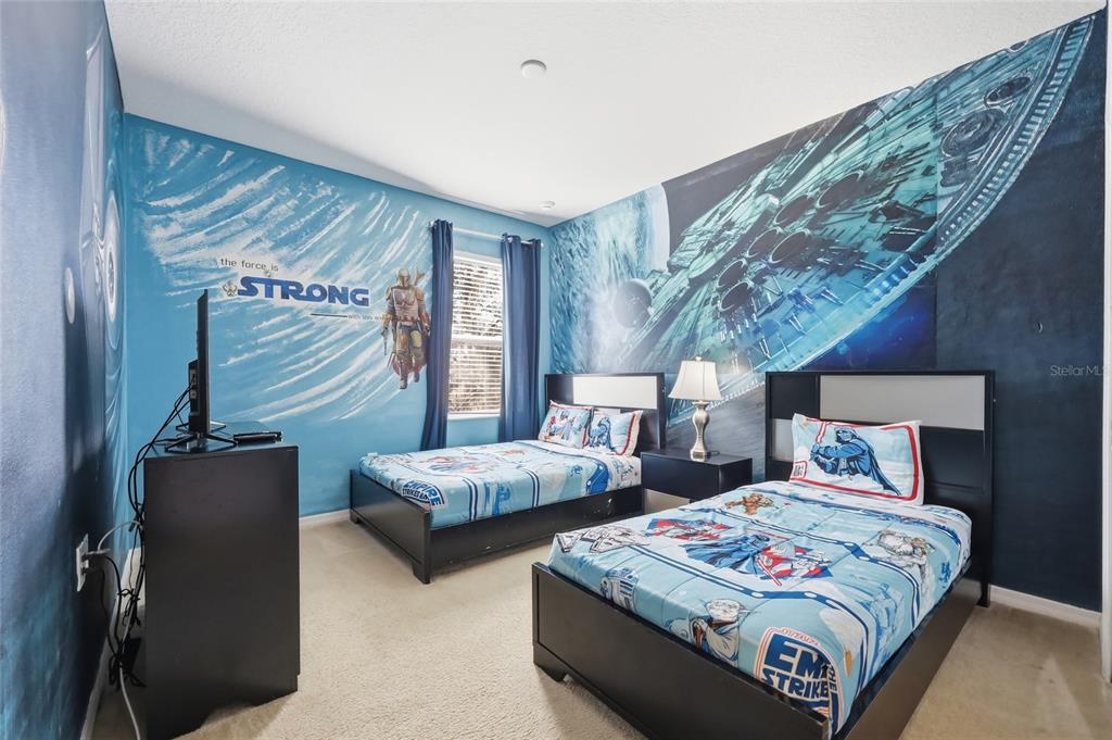A bedroom features two twin beds, Star Wars-themed bedding, and wall murals of space scenes — 6116 BROAD OAK DRIVE, DAVENPORT, FL