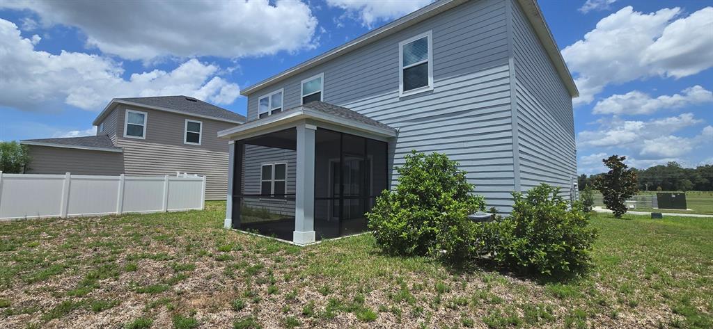 The exterior of a two-story house features light blue siding and a screened-in back porch — 3980 NE 34TH AVENUE, OCALA, FL