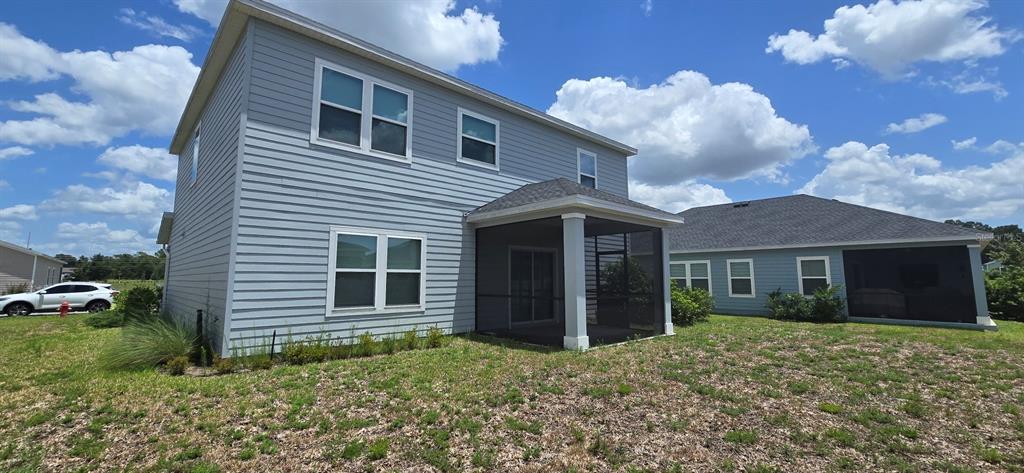 The exterior of a two-story light blue house features a screened-in back porch — 3980 NE 34TH AVENUE, OCALA, FL