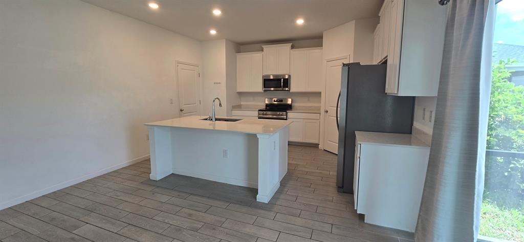 A kitchen features a white island, stainless steel appliances, and light-colored tile flooring — 3980 NE 34TH AVENUE, OCALA, FL