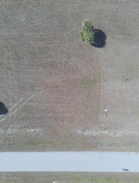 An aerial view shows a vacant, grassy rectangular lot adjacent to a paved road — 12455 BLUE MARLIN ROAD, PLACIDA, FL