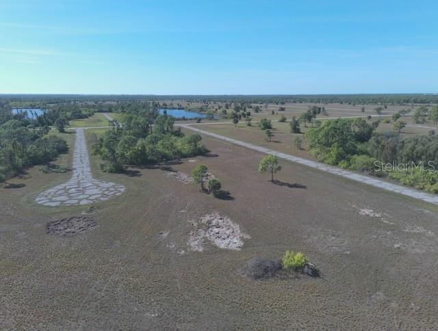 An aerial view shows a vacant, grassy lot with paved roads and distant ponds — 12455 BLUE MARLIN ROAD, PLACIDA, FL