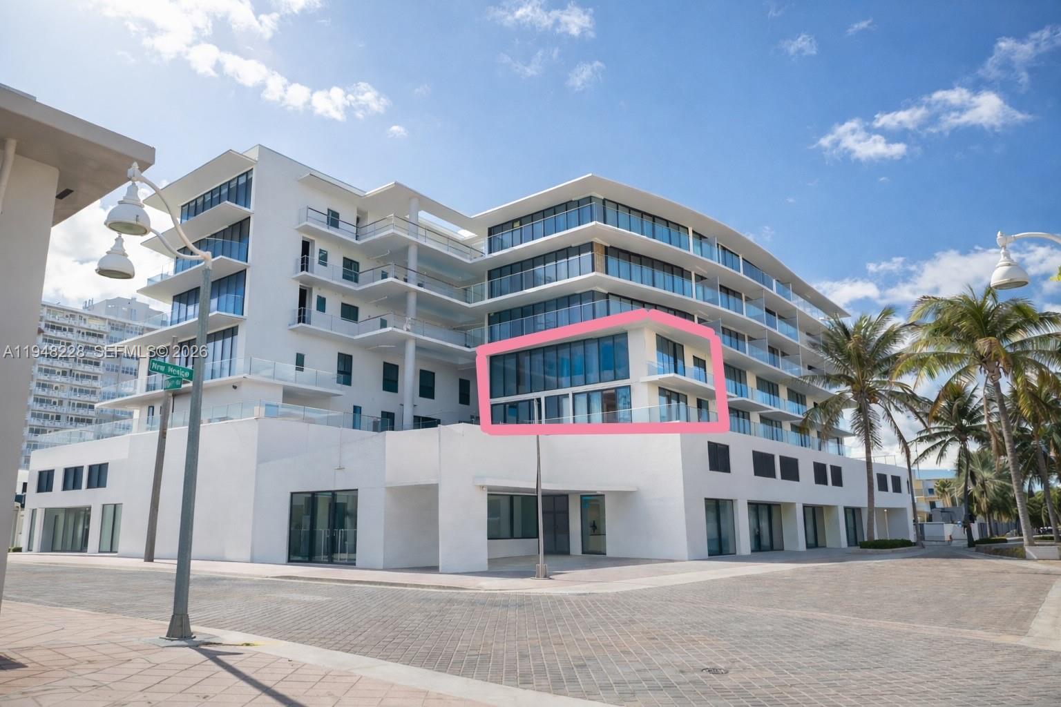 A modern white multi-story building features a highlighted corner unit with glass balconies and windows — 3319 N Ocean Drive, Hollywood FL 33019, HOLLYWOOD, FL