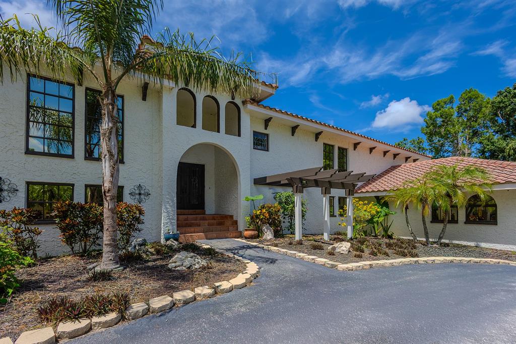 A two-story stucco house with a tile roof, arched entryway, and a circular driveway — 500 N HIGHLAND AVENUE, TARPON SPRINGS, FL