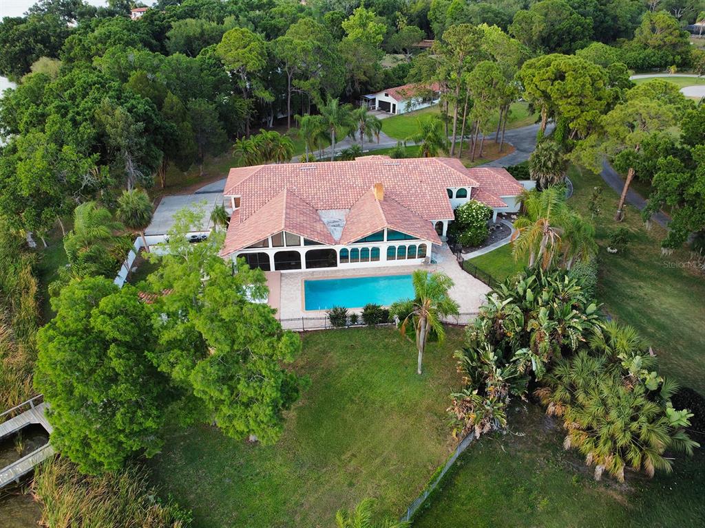 An aerial view shows a house with a red tile roof, pool, and surrounding trees — 500 N HIGHLAND AVENUE, TARPON SPRINGS, FL
