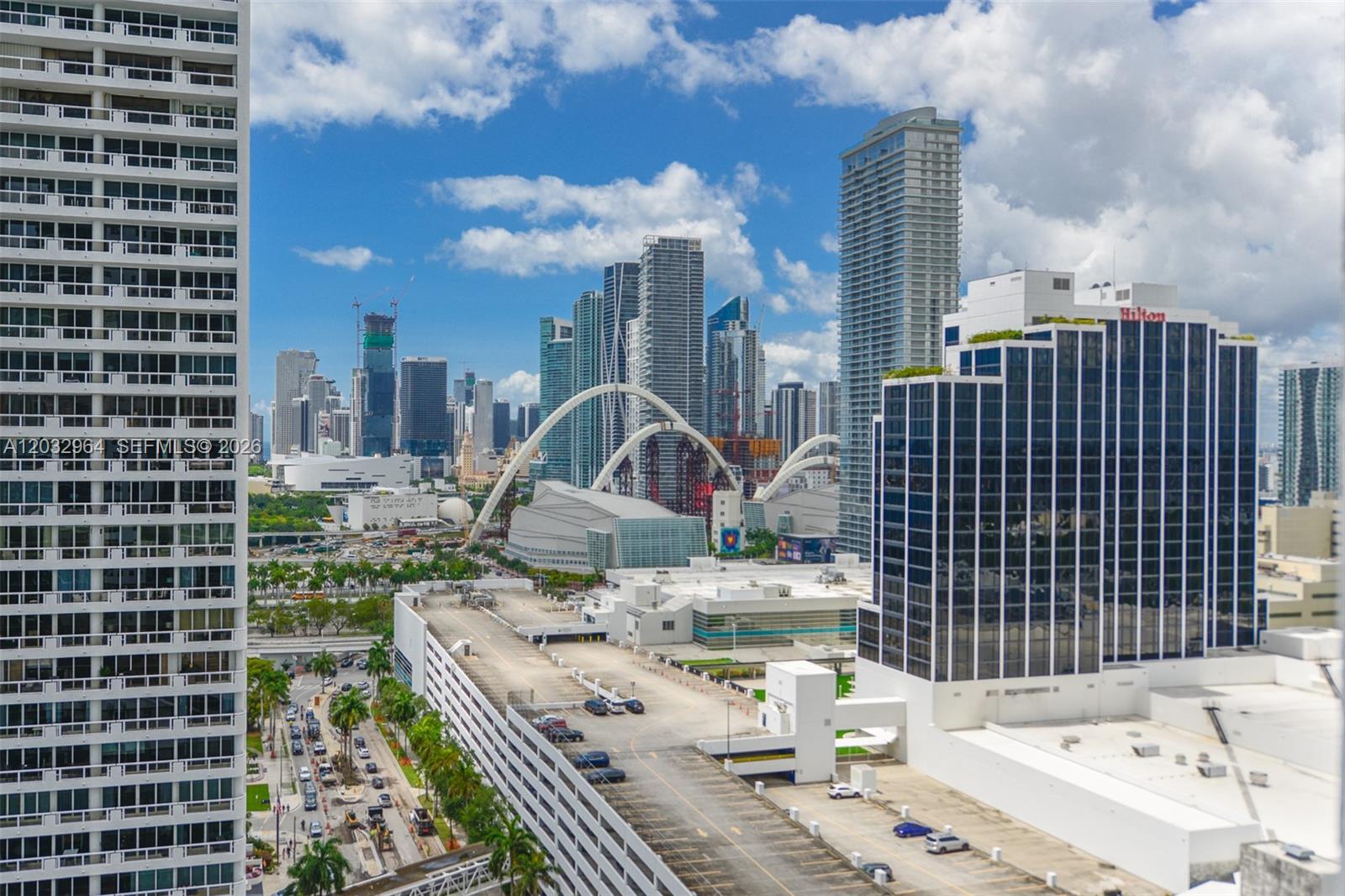 An elevated view of a city skyline featuring skyscrapers, a parking garage, and arched structures — 1750 N Bayshore Dr # 2402, Miami FL 33132, MIAMI, FL
