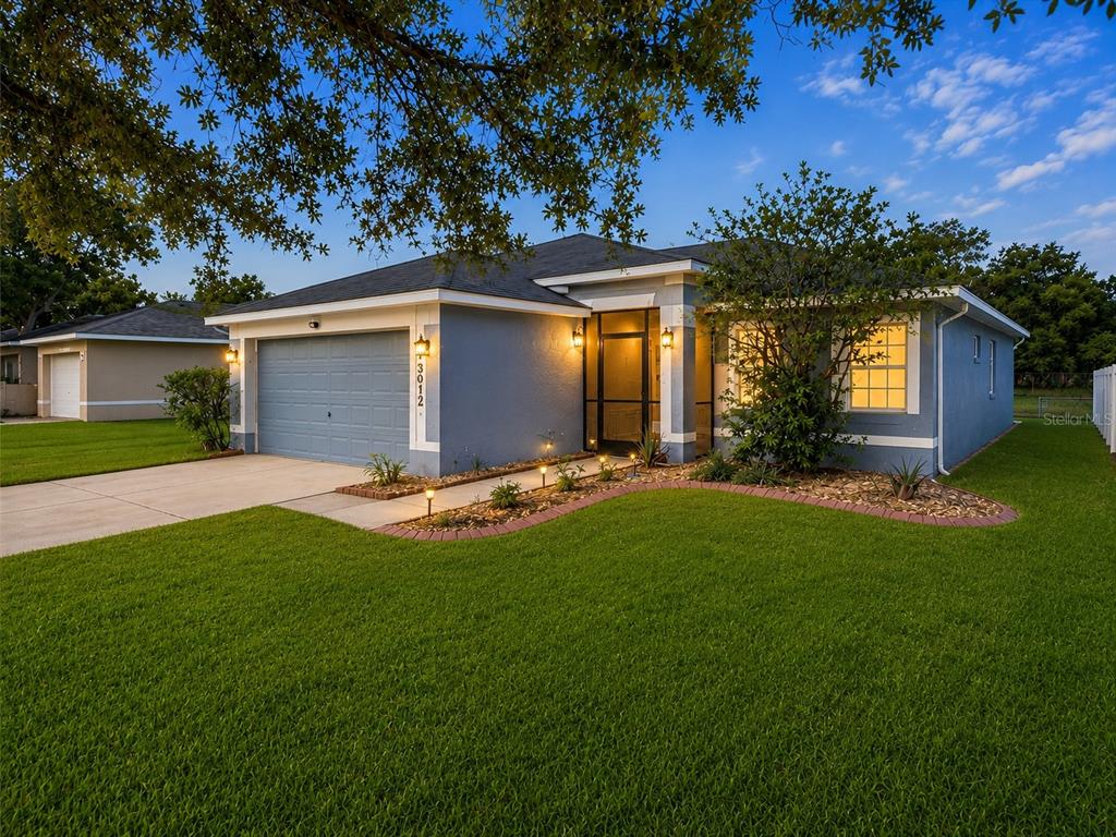 A blue single-story house with a two-car garage and a screened front entryway — 3012 SUMMER HOUSE DRIVE, VALRICO, FL