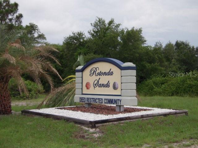 A sign for the Rotonda Sands deed restricted community stands in a grassy area — 80 COXSWAIN CIRCLE, PLACIDA, FL
