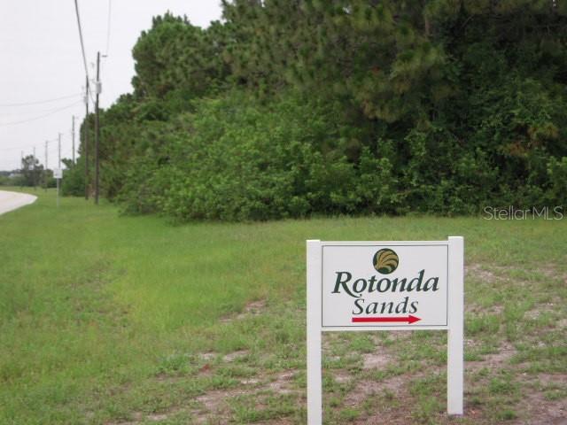 A sign for Rotonda Sands stands in a grassy field near a line of trees — 80 COXSWAIN CIRCLE, PLACIDA, FL