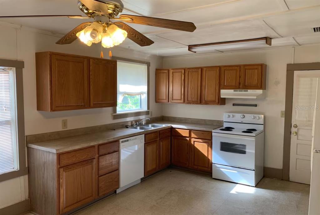 A living room with hardwood floors, a ceiling fan, and a glass-paneled exterior door — 4025 SW 20TH DRIVE, GAINESVILLE, FL