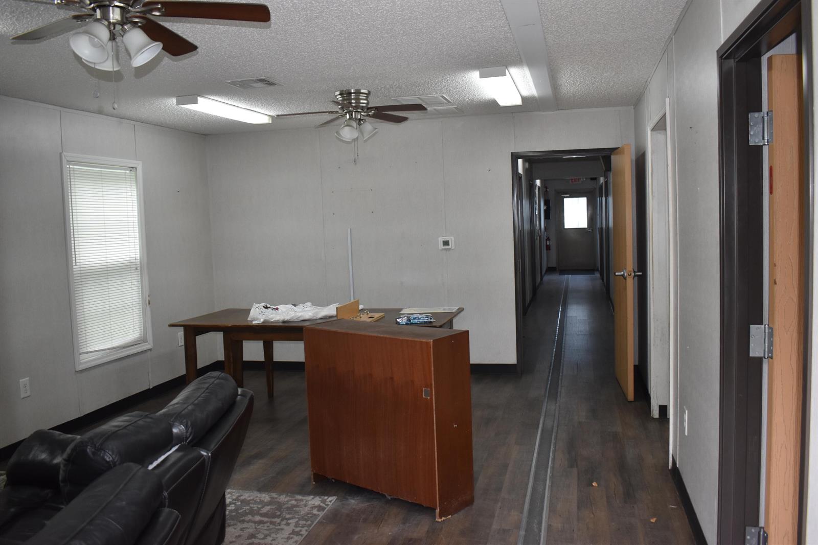A room with a ceiling fan, a wooden desk, a leather chair, and a hallway — 1893 90th Avenue, Vero Beach FL 32966, VERO BEACH, FL