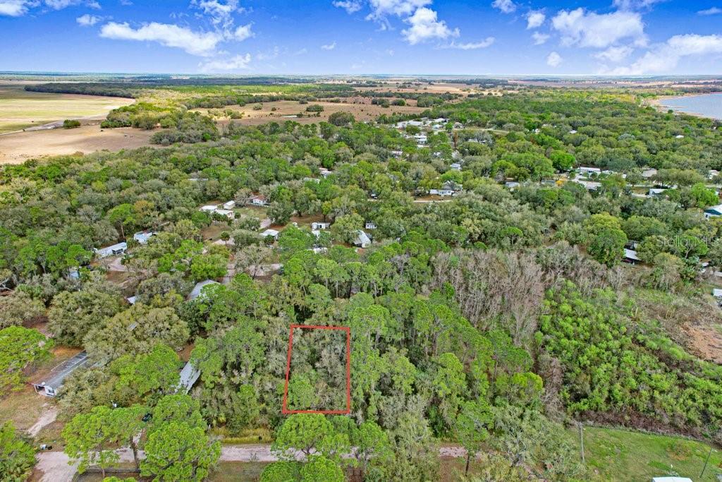 An aerial view shows a rectangular plot of land outlined in red amidst dense trees — 0 YUCATAN DRIVE, LAKE WALES, FL