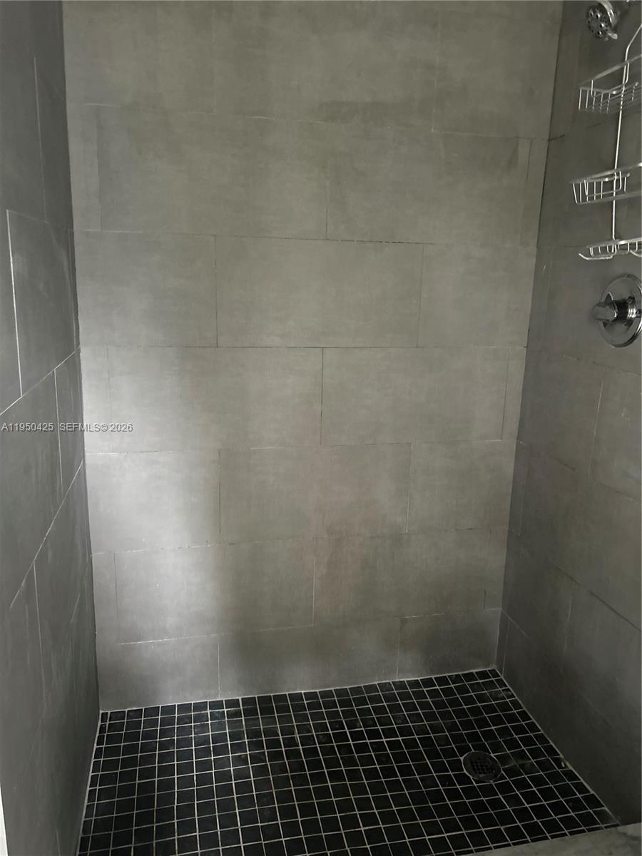 A walk-in shower features gray rectangular wall tiles and a black square-tiled floor — 2300 NW 94th St # 0, Miami FL 33147, MIAMI, FL