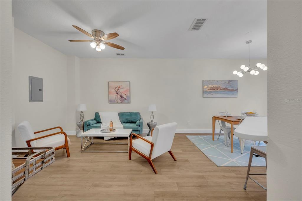 A living and dining area features light wood flooring, white walls, and modern furniture — 1172 S BEACH CIRCLE, KISSIMMEE, FL
