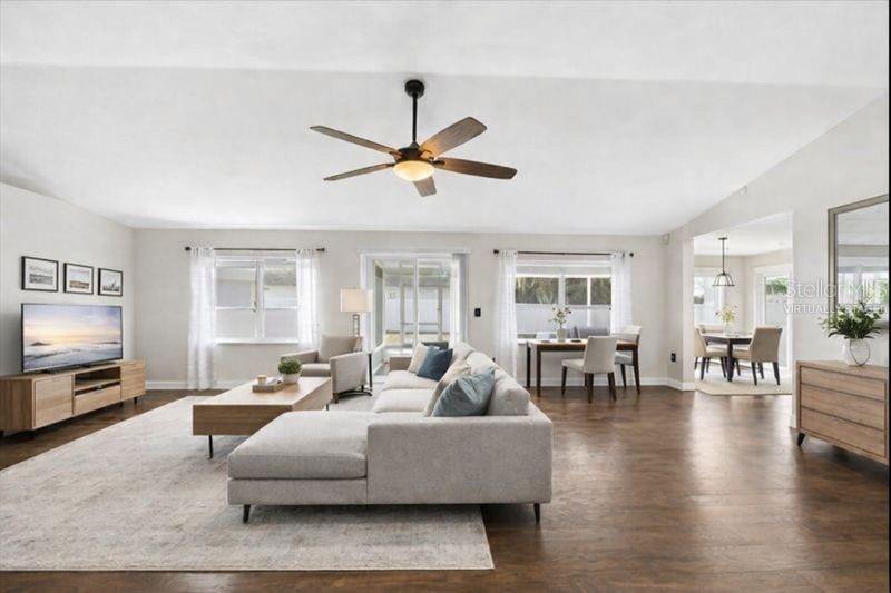 A living room features a ceiling fan, a television on a console, and a sofa — 6789 ASHBURY DRIVE, LAKELAND, FL