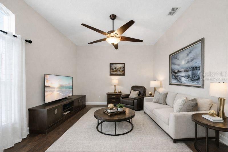 A kitchen features light wood cabinets, a black island, stainless steel appliances, and tile flooring — 6789 ASHBURY DRIVE, LAKELAND, FL