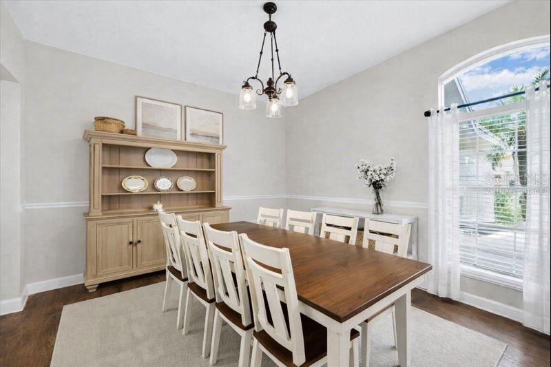A bedroom features a wooden bed frame, a dresser, a ceiling fan, and hardwood floors — 6789 ASHBURY DRIVE, LAKELAND, FL