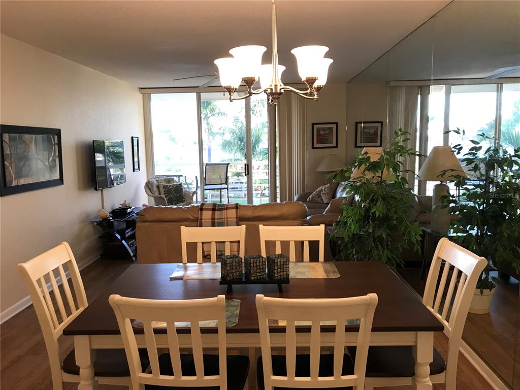 A dining area with a dark wood table and white chairs sits before a living room — 6061 BAHIA DEL MAR CIRCLE UNIT 347, ST PETERSBURG, FL