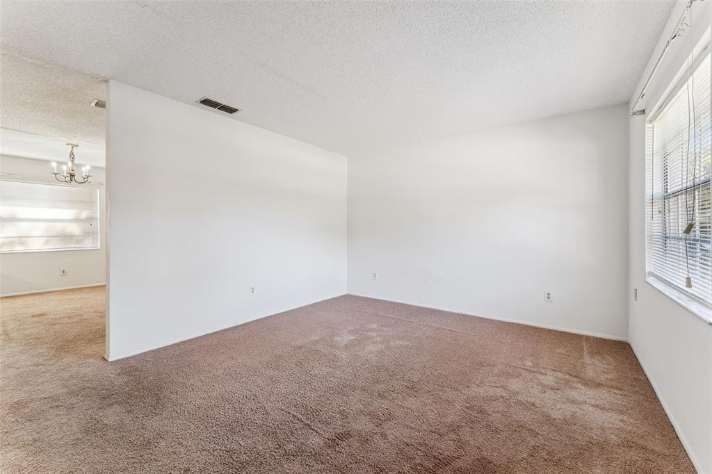 An empty room with brown carpet, white walls, and a window with blinds — 306 LOCH LOW DRIVE, SANFORD, FL
