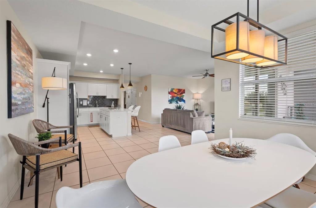 An open-concept living area features a dining space, kitchen with island, and a living room — 4741 CLOCK TOWER DRIVE UNIT 203, KISSIMMEE, FL