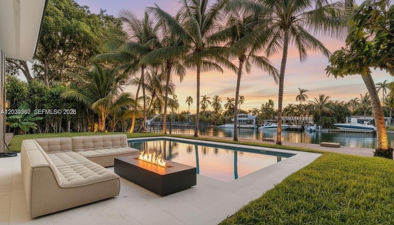 An outdoor patio features a modern sofa, a rectangular fire pit, and a swimming pool — 550 S Shore Dr, Miami Beach FL 33141, MIAMI BEACH, FL