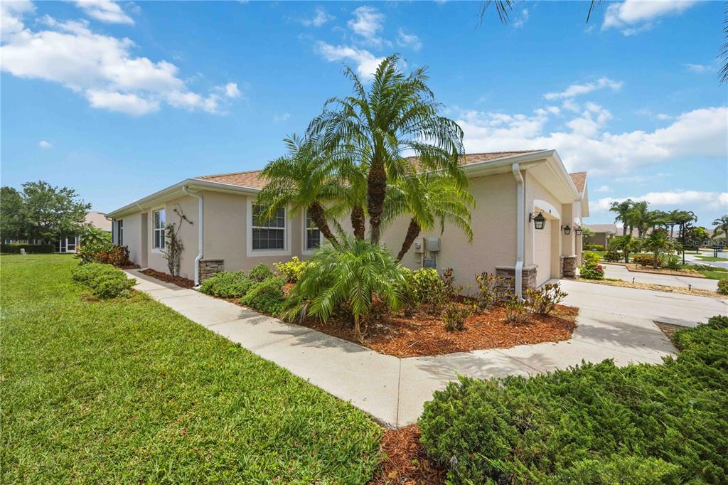A side view of a beige house with a palm tree and a concrete walkway — 4249 LENOX BOULEVARD, VENICE, FL