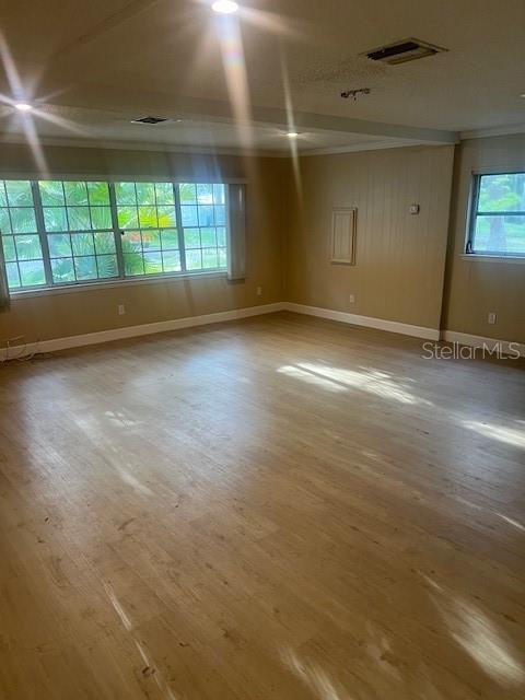 A spacious room features light wood-look flooring, tan walls, and large windows with exterior views — 16406 LAKE BYRD DRIVE, TAMPA, FL