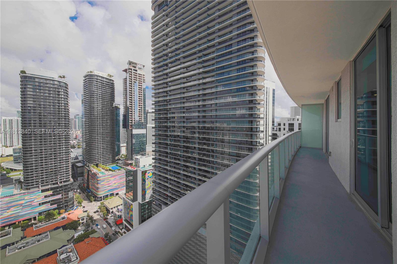 A high-rise balcony overlooks a dense urban cityscape with multiple modern skyscrapers — 1100 S Miami Ave # 3607, Miami FL 33130, MIAMI, FL