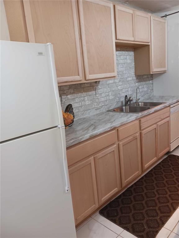 A kitchen features light wood cabinets, a marble-patterned countertop, and a faux brick backsplash — 2901 NW 48TH AVENUE UNIT 367, LAUDERDALE LAKES, FL