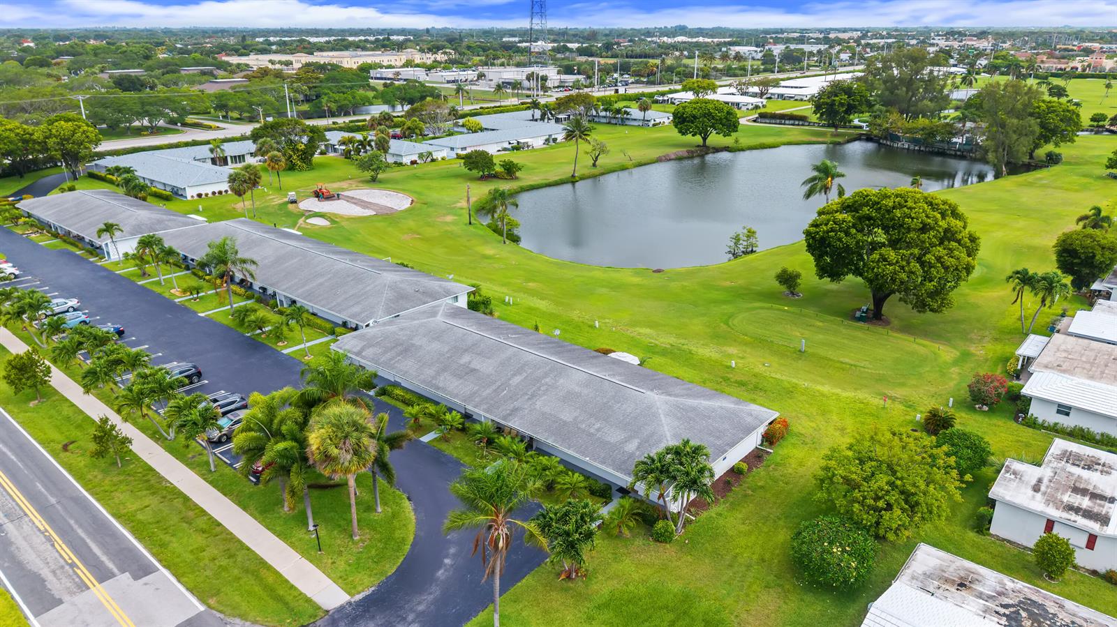 An aerial view shows a long residential building next to a pond and golf course — 2017 SW Golf Lane # 113, Boynton Beach FL 33426, BOYNTON BEACH, FL