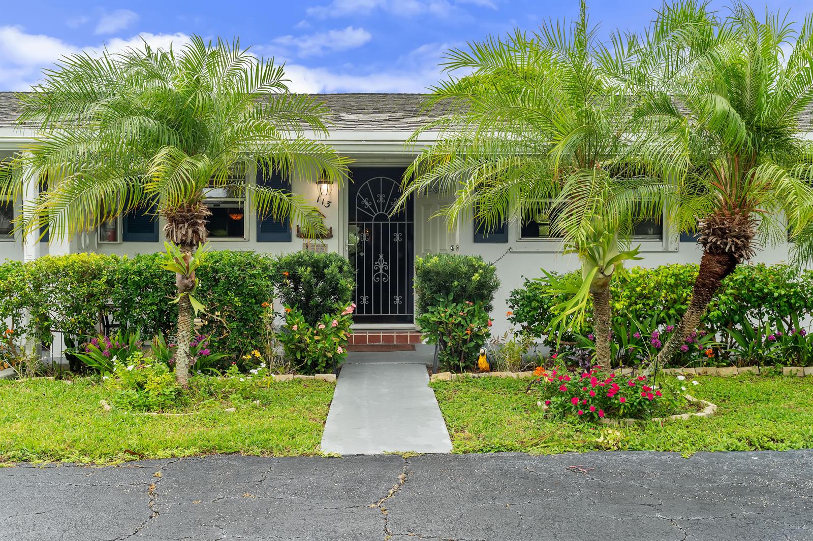 A single-story house exterior features two palm trees, a concrete walkway, and a decorative door — 2017 SW Golf Lane # 113, Boynton Beach FL 33426, BOYNTON BEACH, FL