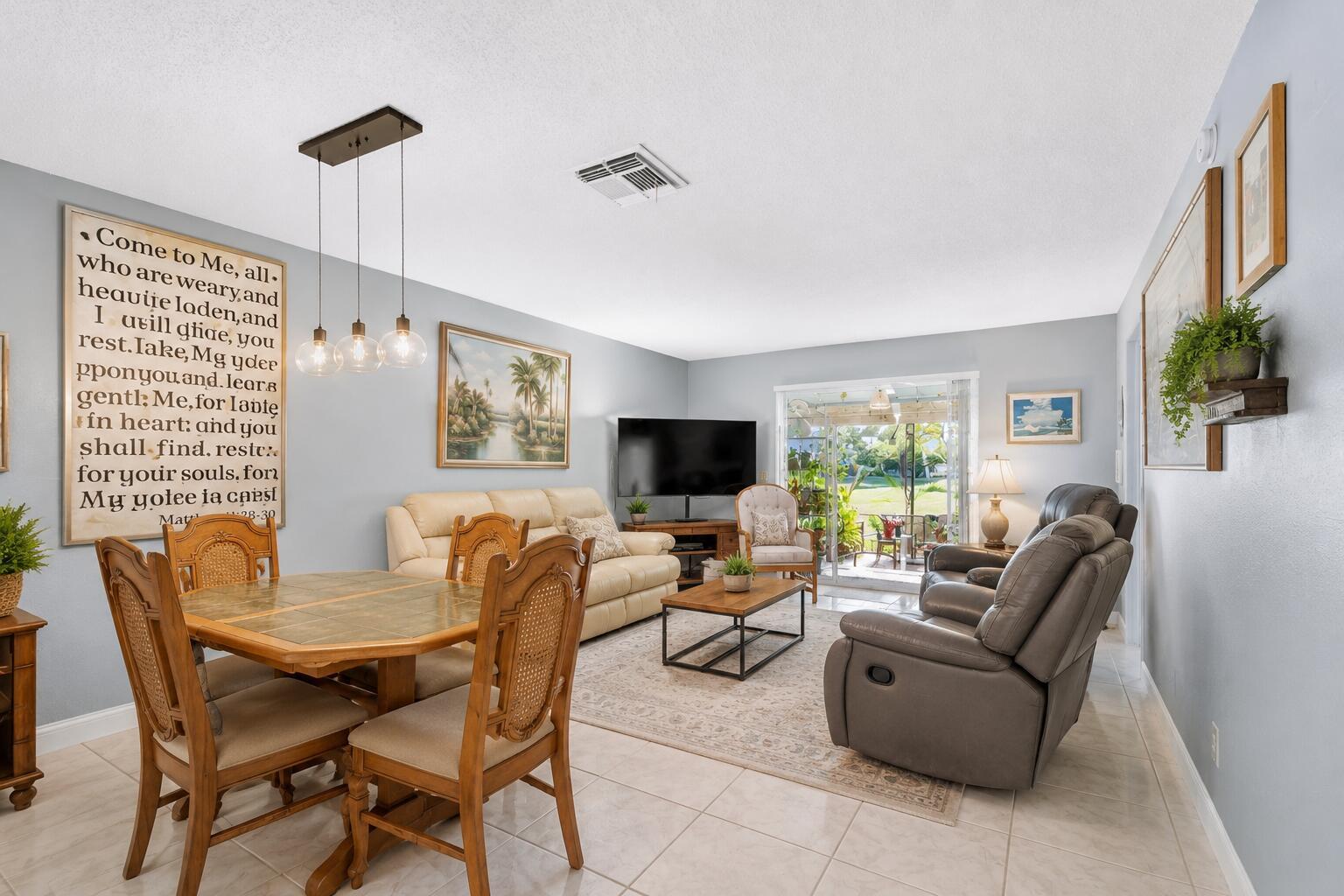 A living and dining area features light gray walls, tile flooring, and a sliding glass door — 2017 SW Golf Lane # 113, Boynton Beach FL 33426, BOYNTON BEACH, FL