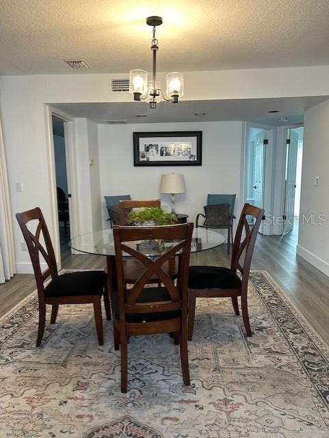 A dining area features a glass-topped table, four wooden chairs, and a patterned area rug — 4352 AQUA VISTA DRIVE UNIT 9D, ORLANDO, FL