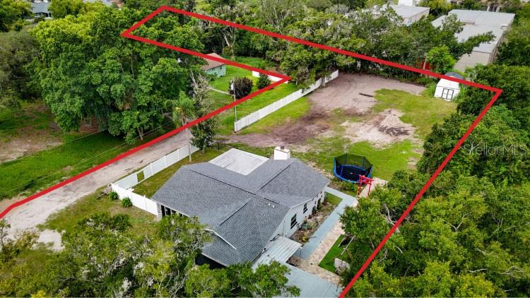 An aerial view shows a house with a large fenced yard and a trampoline — 11635 131ST STREET, LARGO, FL