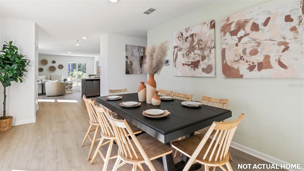 This is a rendering of a dining room featuring a black table and wooden chairs — 17 FLAGSTICK LANE, BUNNELL, FL