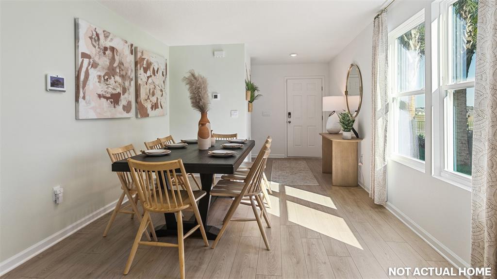 A dining room features a dark wood table, light wood chairs, and light flooring — 17 FLAGSTICK LANE, BUNNELL, FL