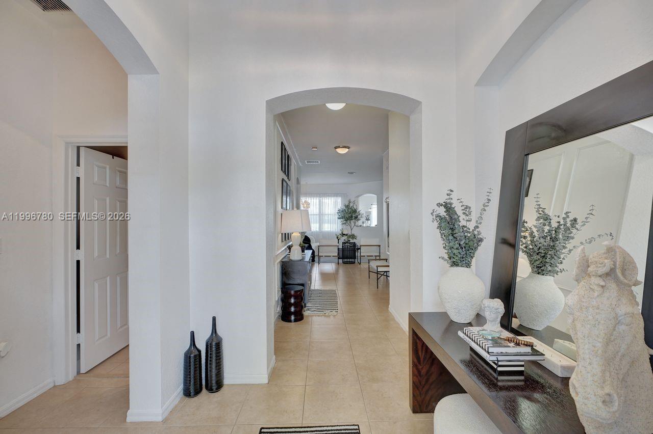 A tiled entryway leads through an arched doorway into a bright, open-concept living area — 3982 W Whitewater Ave, Weston FL 33332, WESTON, FL