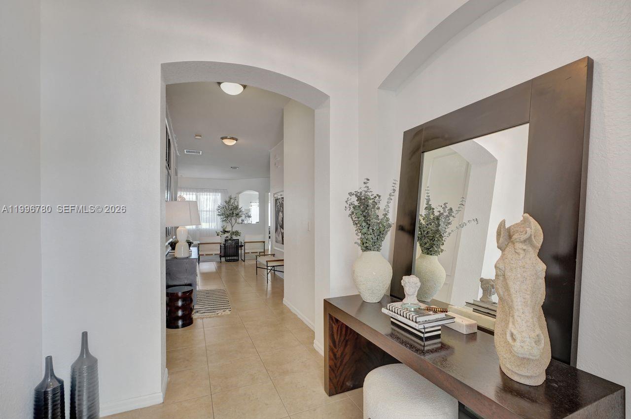 A hallway with tile flooring leads through an arched doorway toward a living area — 3982 W Whitewater Ave, Weston FL 33332, WESTON, FL