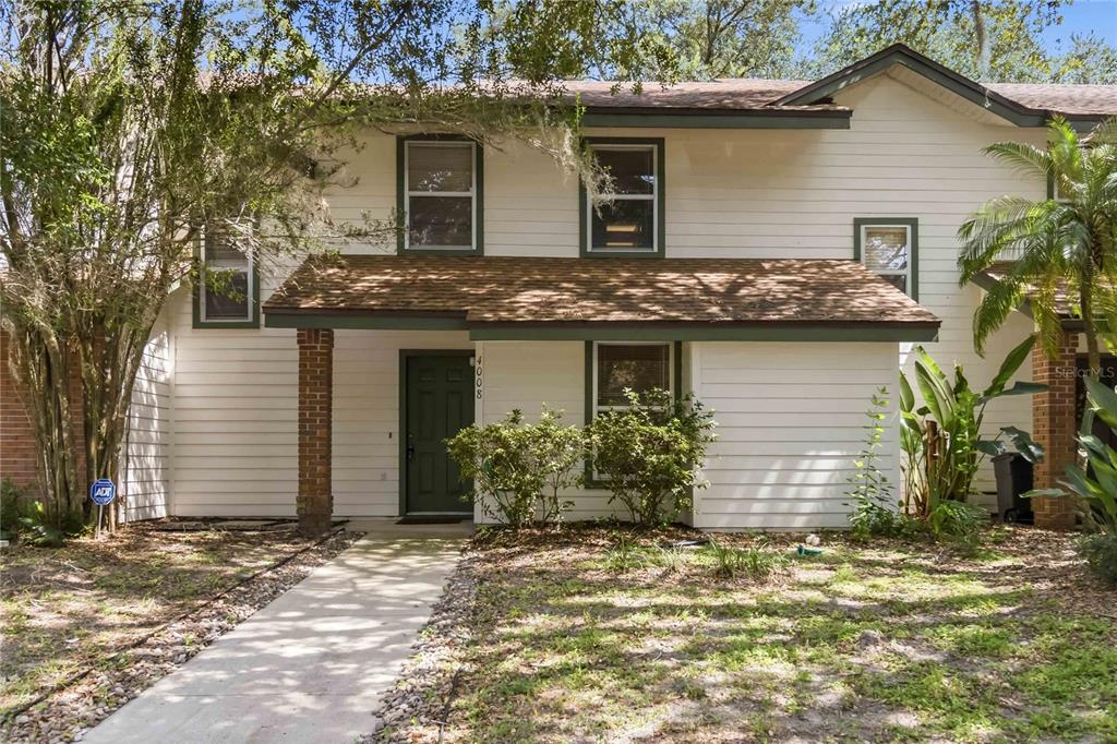 A two-story house with white horizontal siding, a brown shingled roof, and a brick-accented entryway — 4008 W MARYLAND PLACE, CASSELBERRY, FL
