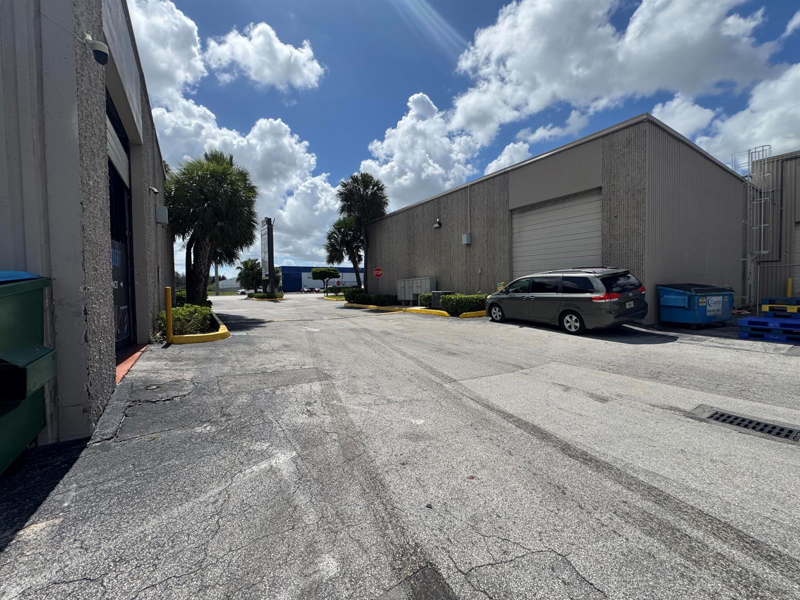 An exterior view of a commercial building with a parking lot and a parked minivan — 2710 NW 72nd Avenue, Miami FL 33122, MIAMI, FL