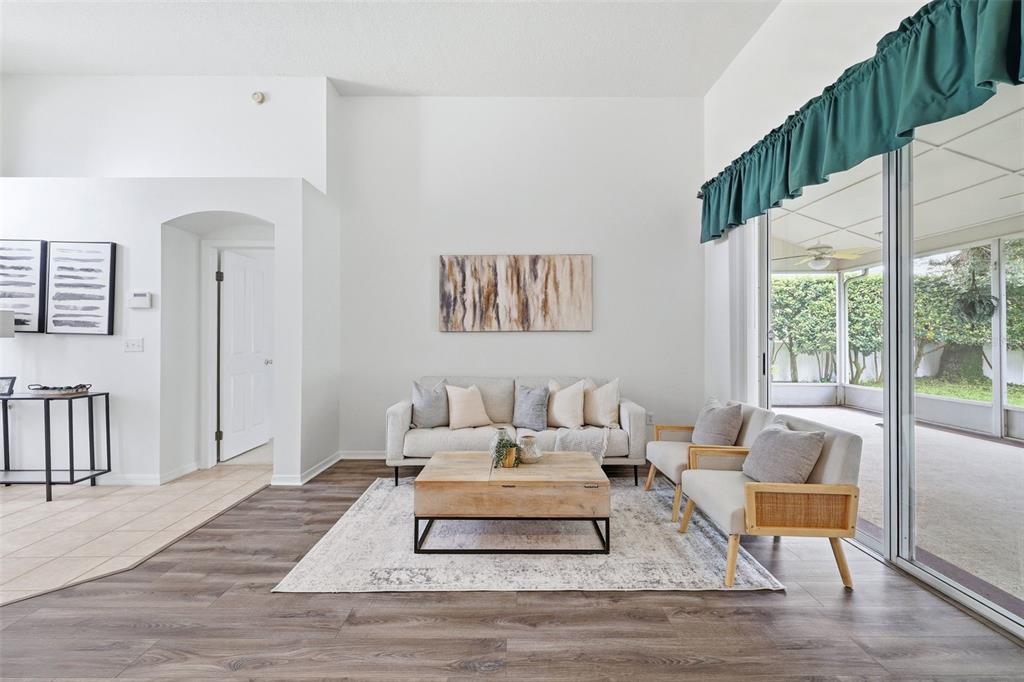 A living room features a sofa, two chairs, a coffee table, and a sliding glass door — 28331 OPENFIELD LOOP, WESLEY CHAPEL, FL