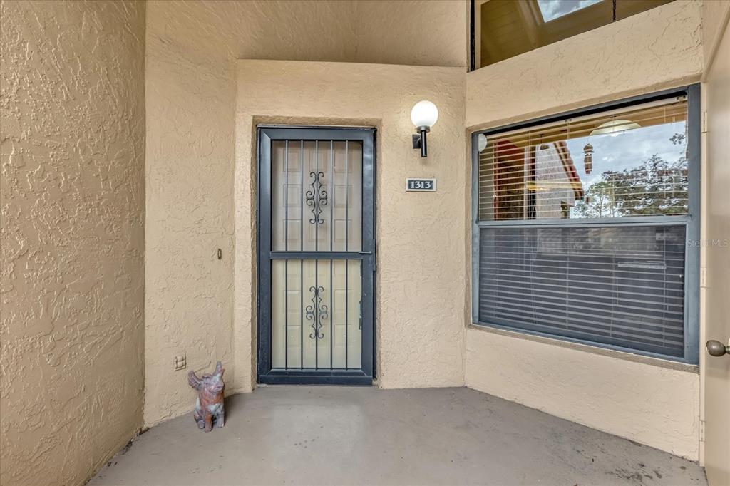 An exterior view of a home entrance featuring a security screen door and a window — 1313 LAKE WILLISARA CIRCLE UNIT 1313, ORLANDO, FL