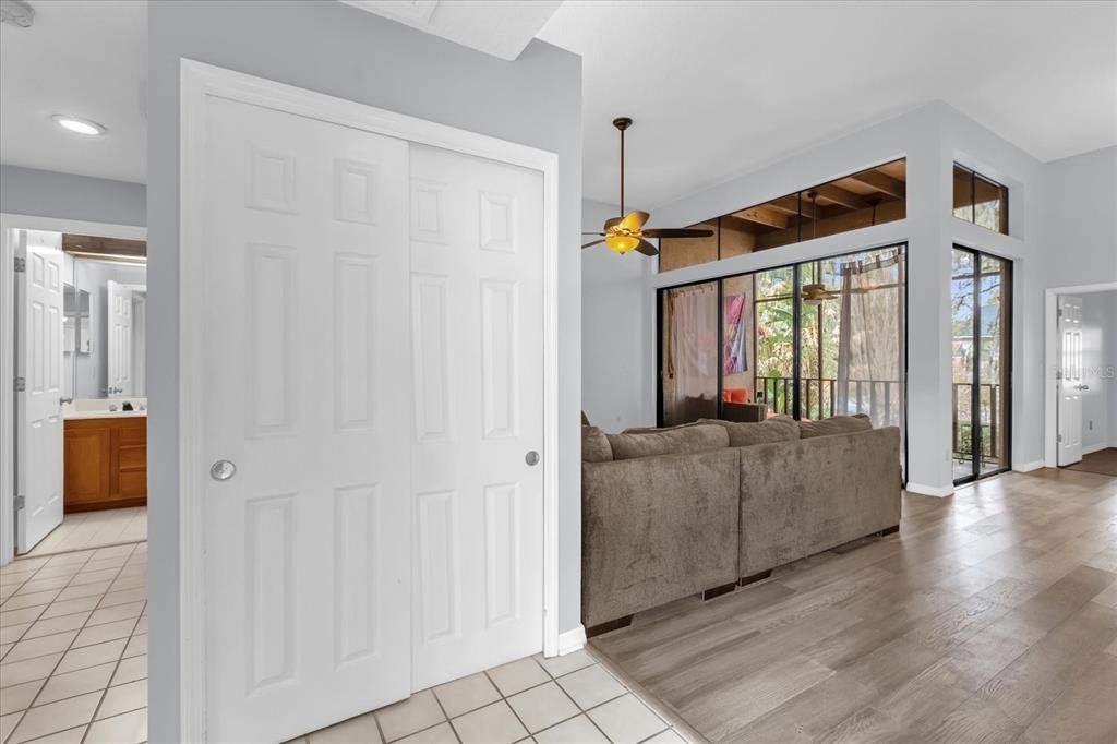 A living room with wood-look flooring, a sliding glass door, and a white closet door — 1313 LAKE WILLISARA CIRCLE UNIT 1313, ORLANDO, FL