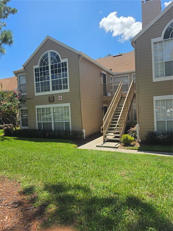 A two-story apartment building features tan siding, large arched windows, and an exterior staircase — 705 YOUNGSTOWN PARKWAY UNIT 356, ALTAMONTE SPRINGS, FL