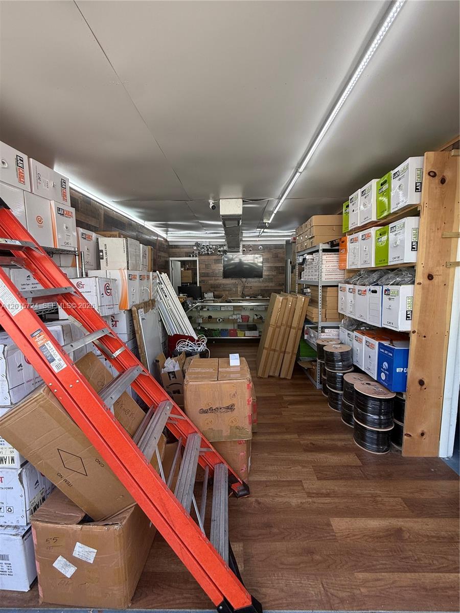 A storage room filled with boxes of cables, equipment, and a ladder on a wood floor — 1775 Blount Rd # 410, Pompano Beach FL 33069, POMPANO BEACH, FL