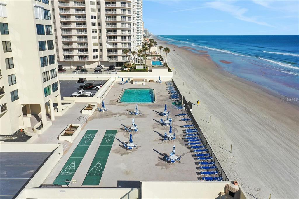 An aerial view shows a beachfront pool deck with shuffleboard courts and lounge chairs — 2987 S ATLANTIC AVENUE UNIT 205, DAYTONA BEACH SHORES, FL