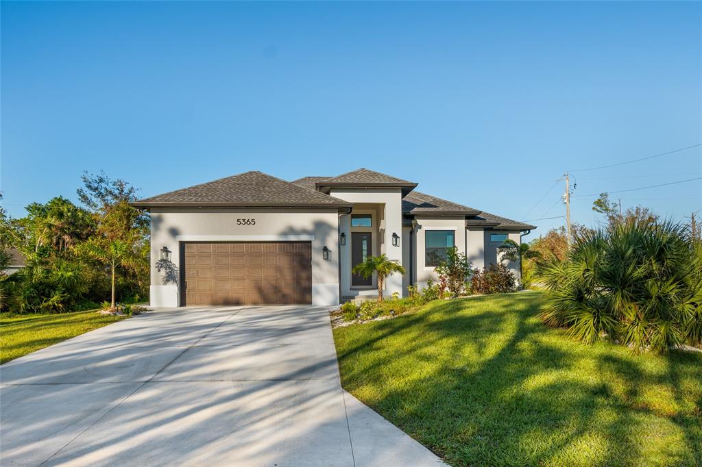 A single-story house with a brown garage door, gray stucco exterior, and a concrete driveway — 5365 CRAIG TERRACE, PORT CHARLOTTE, FL